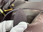 Louis Vuitton monogram bag edge detail with leather tab and stamped emblem