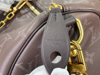 Louis Vuitton bag handle close-up in dark leather with gold chain and LV embossed logo