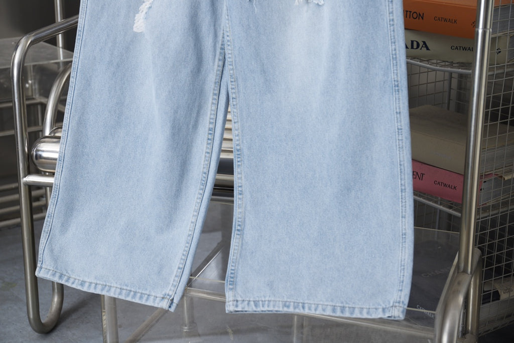 Light blue denim pants with wide leg and unfinished frayed hem