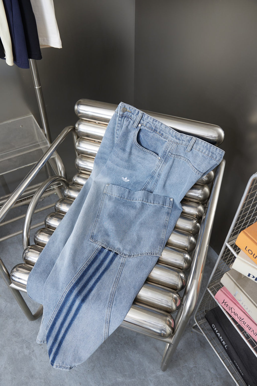 Light blue denim cargo pants on a metal rack with striped side accents