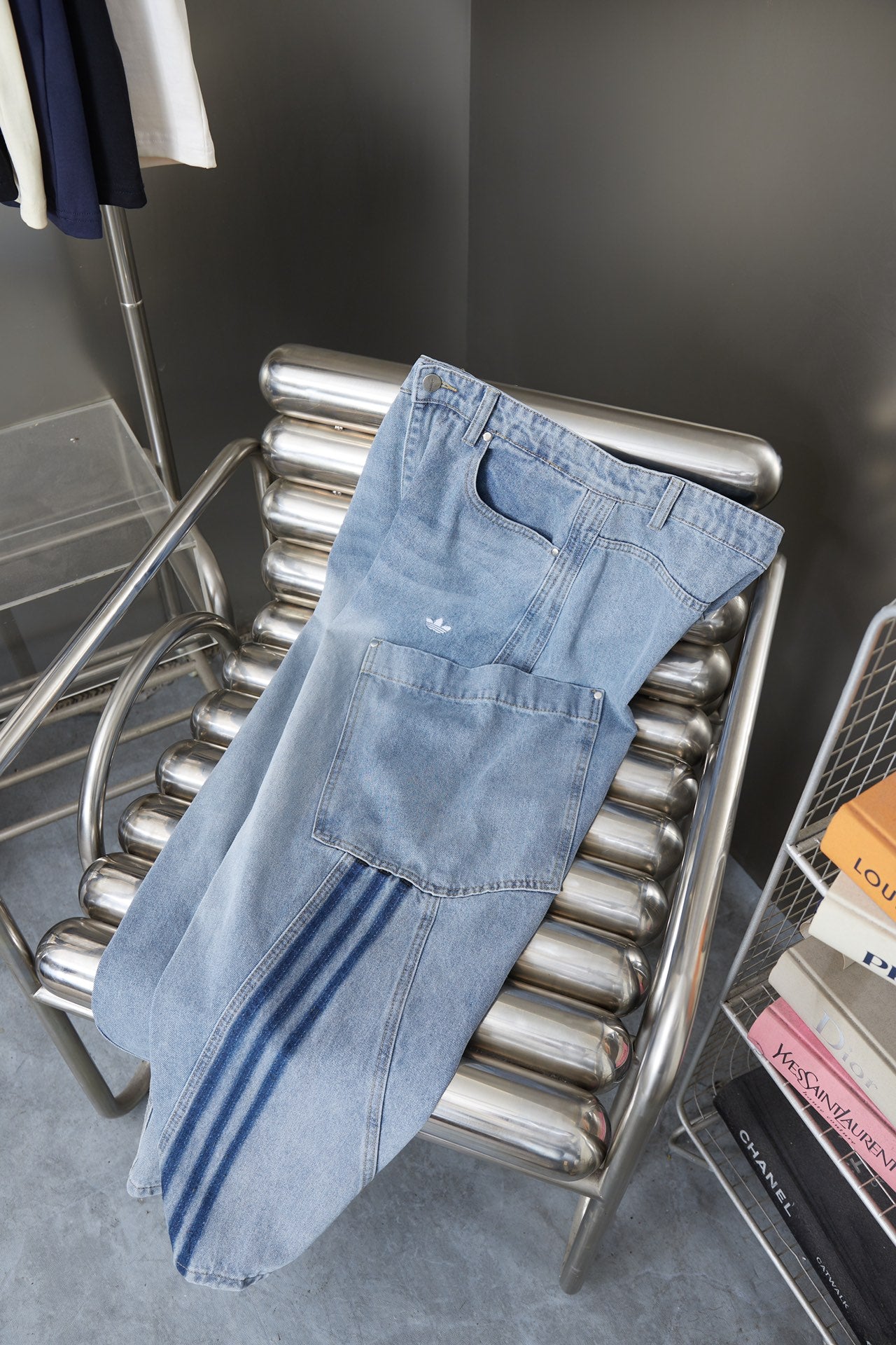 Light blue denim cargo pants on a metal rack with striped side accents