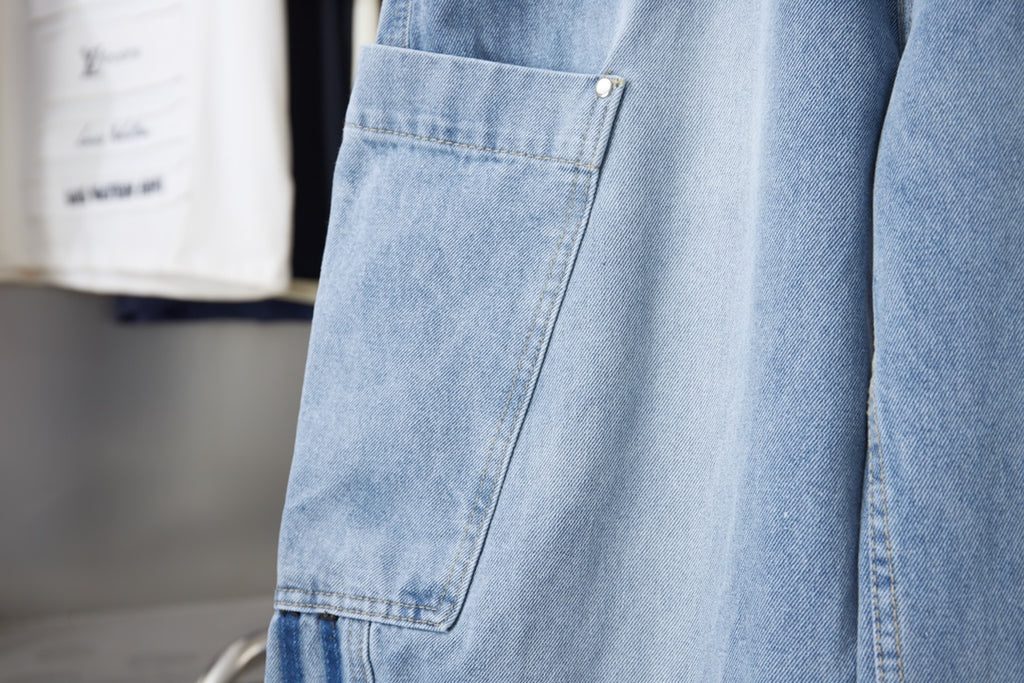 Light blue denim cargo pocket with button and angled seam detail