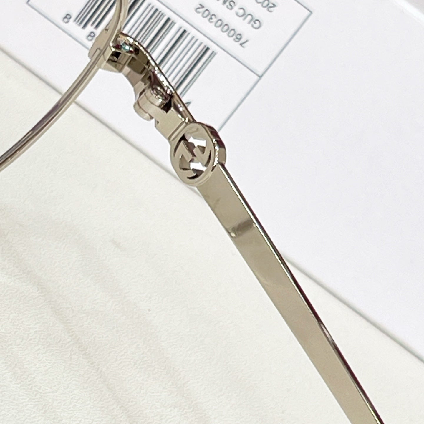 Gucci eyeglasses hinge close-up with metal temple arm and logo detail
