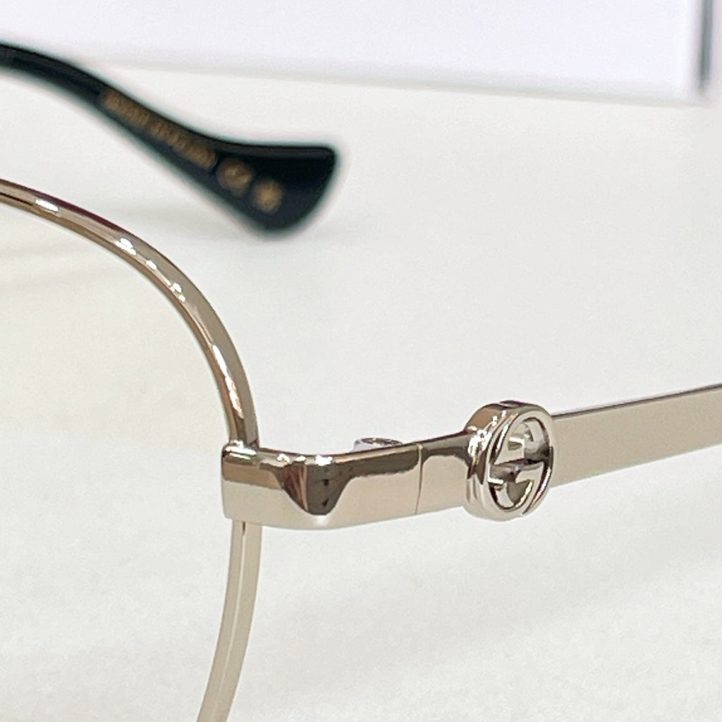 Gucci eyeglasses frame close-up with gold temples and clear lenses