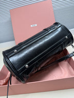 Black leather shoulder bag with long front flap, snap buttons, and crossbody strap