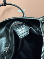 Black leather bag interior with Miu Miu logo label patch