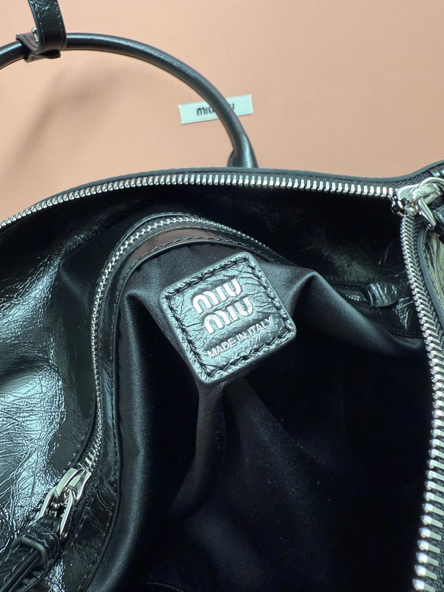 Black leather bag interior with Miu Miu logo label patch