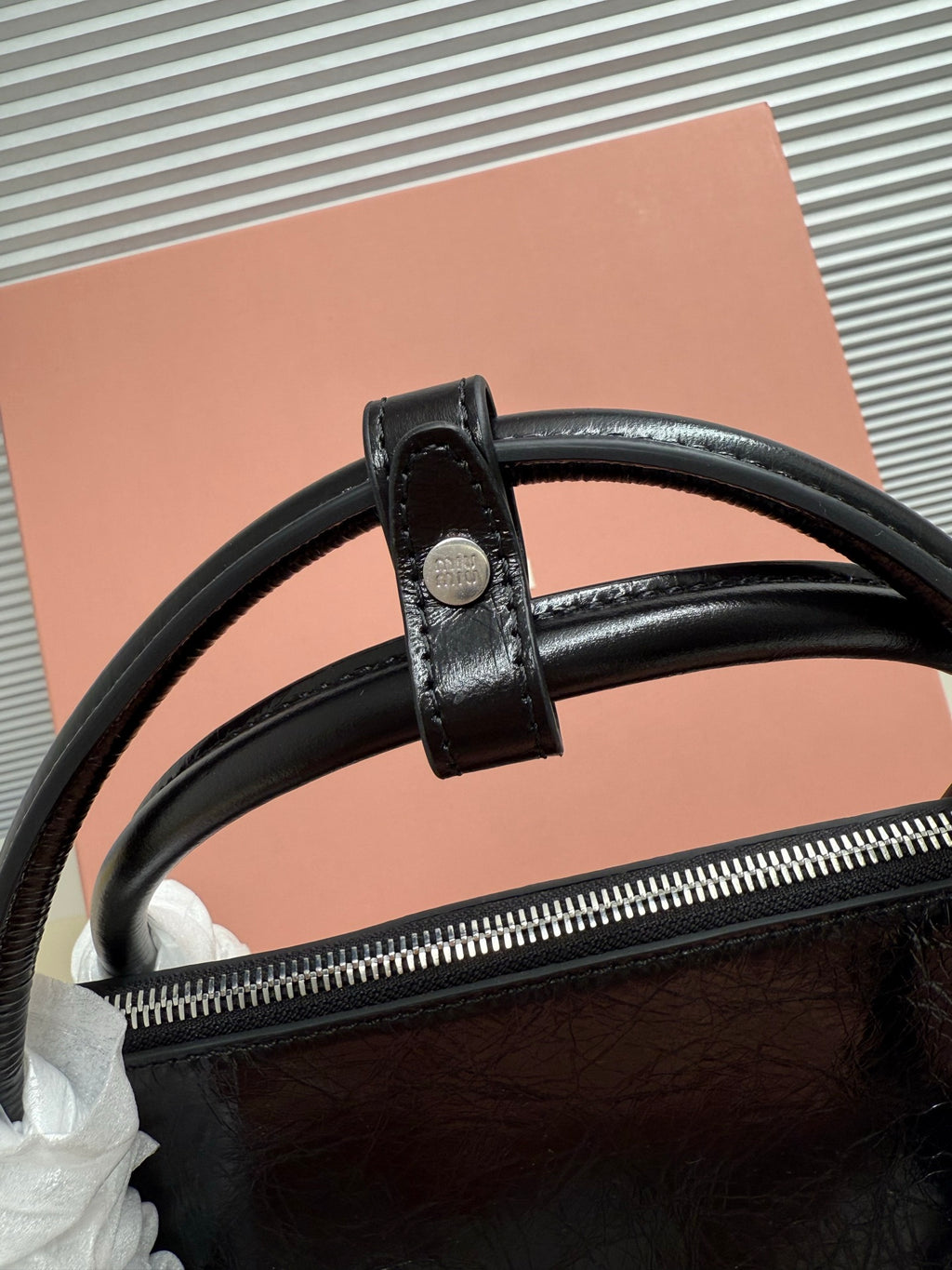 Black leather handbag top zipper with strap loop and wide leather handle