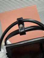 Black leather handbag top zipper with strap loop and wide leather handle