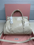 Ivory leather handbag with top handles, front logo, and silver-tone hardware