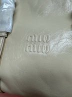 Ivory leather handbag front with embossed “miu miu” logo detail