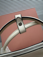 White leather handbag top handle with stitched leather tab and metal attachment ring