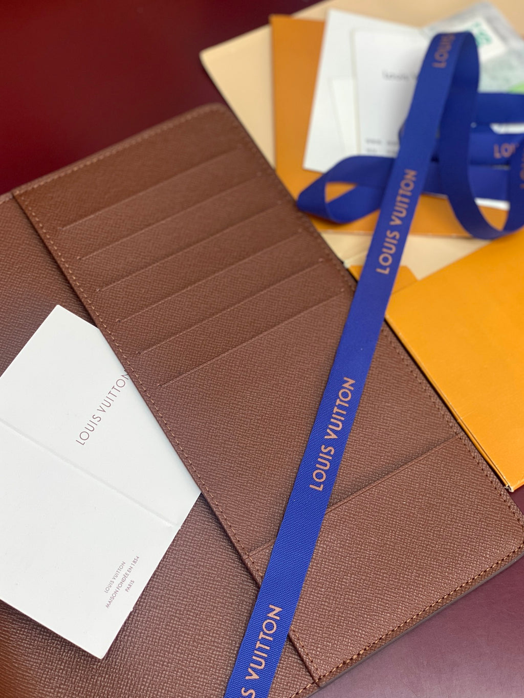 Louis Vuitton brown leather card holder, textured finish with multiple card slots.
