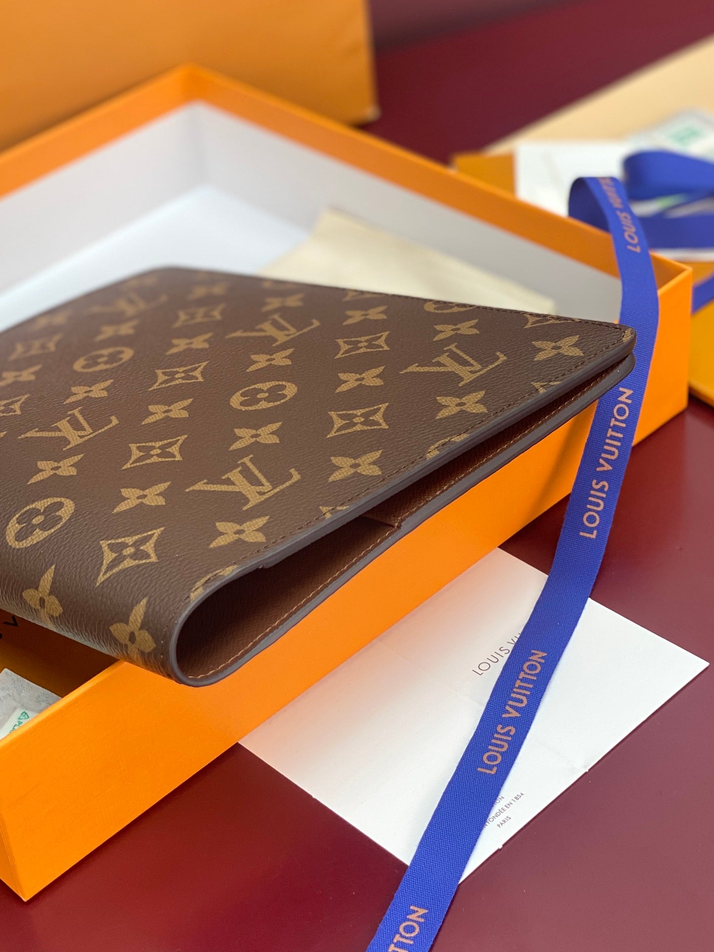 Louis Vuitton small monogram canvas wallet, side view with curved leather edge
