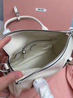White leather bag interior view with zipper pocket and logo patch at top