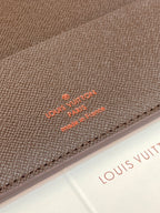 Close-up of Louis Vuitton small wallet: dark brown textured leather with embossed logo