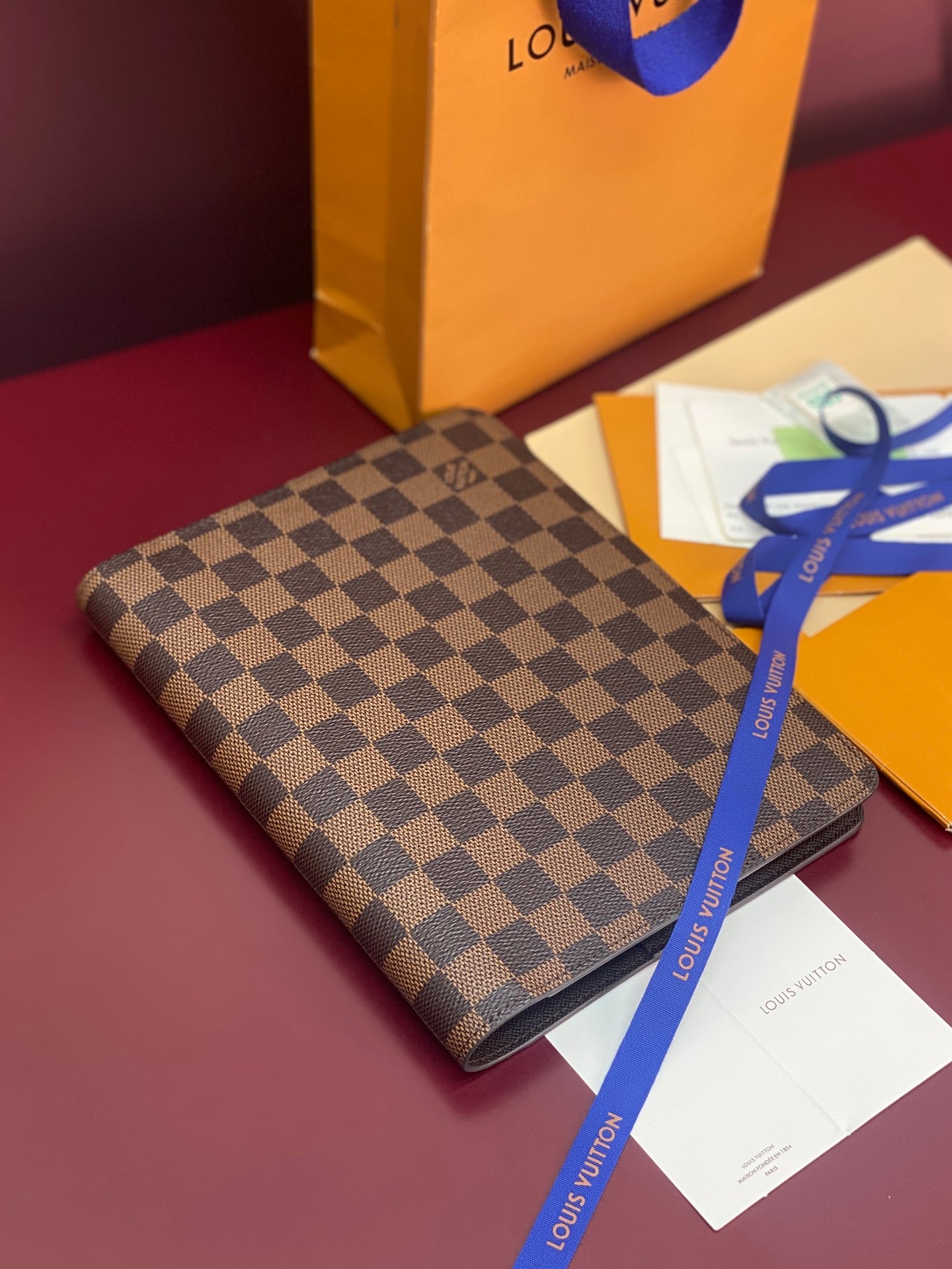 Louis Vuitton small wallet with dark brown checkered canvas, angled front view