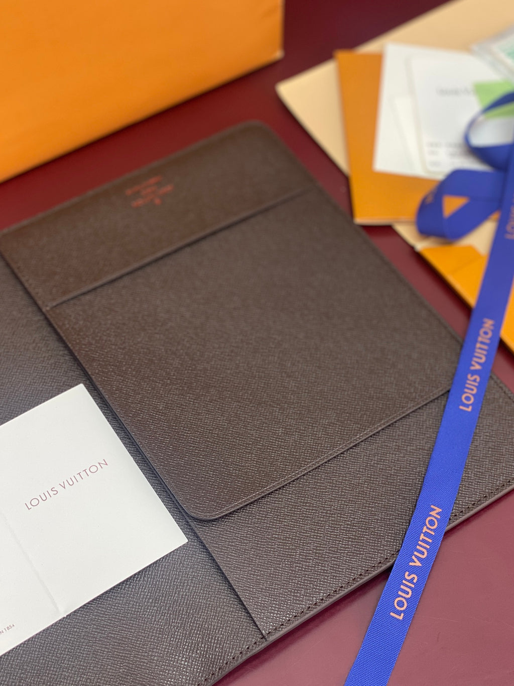Louis Vuitton small wallet in dark brown textured leather with embossed logo on cover