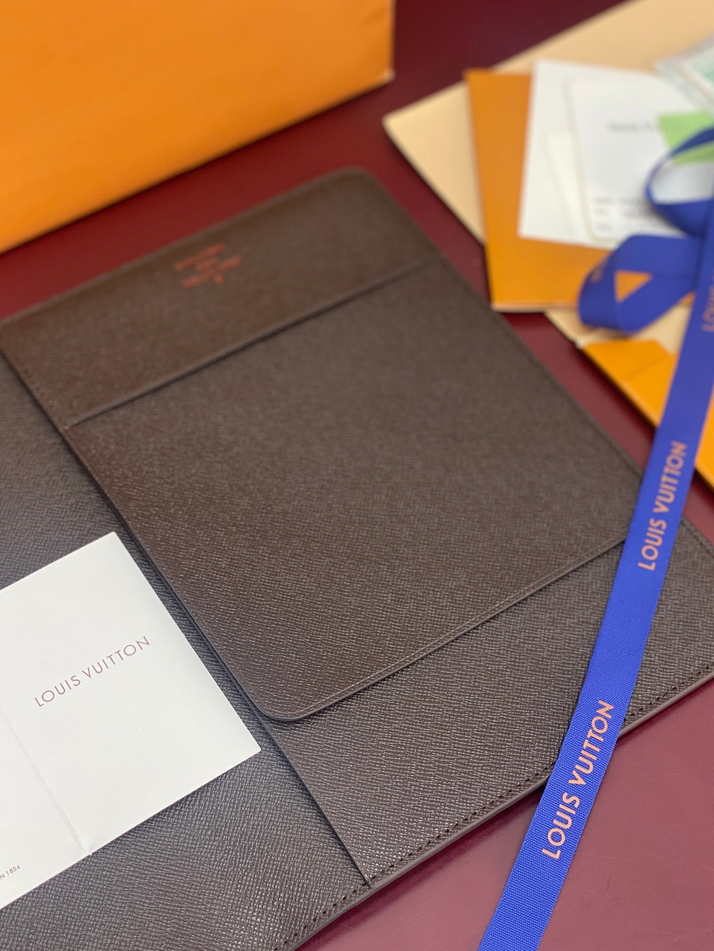 Louis Vuitton small wallet in dark brown textured leather with embossed logo on cover