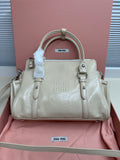 Light green leather handbag with zip top, dual handles, front logo plaque and buckles