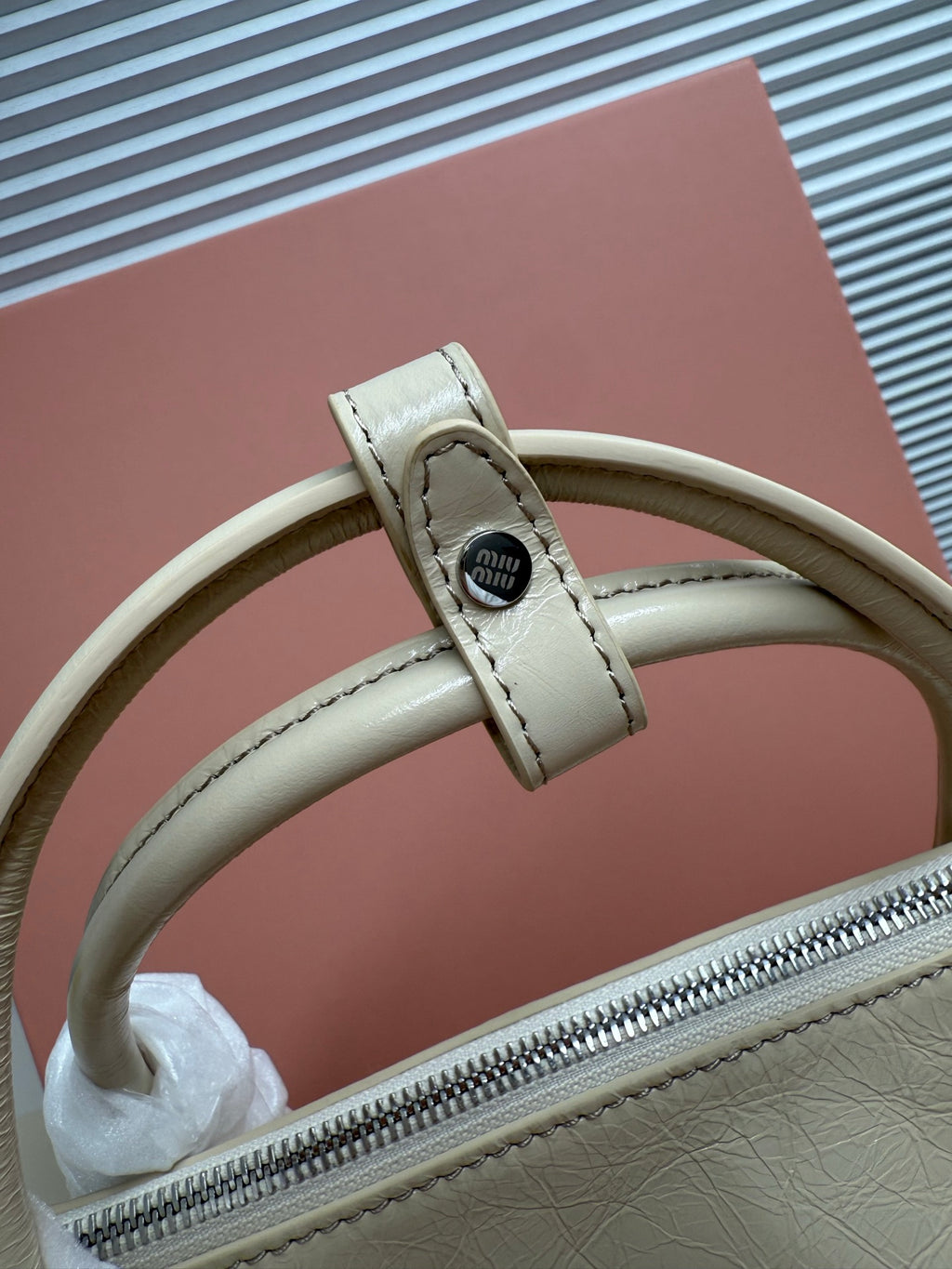 Light green leather handbag zipper pull with crossbody strap and metal snap buckle