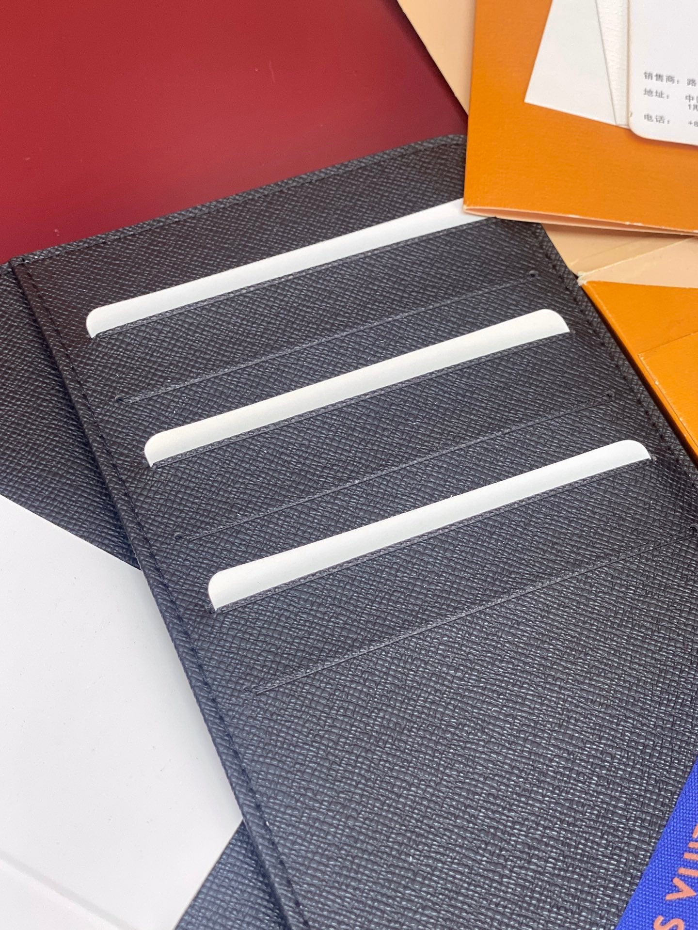 Louis Vuitton card holder wallet, dark textured leather with three white slot lines