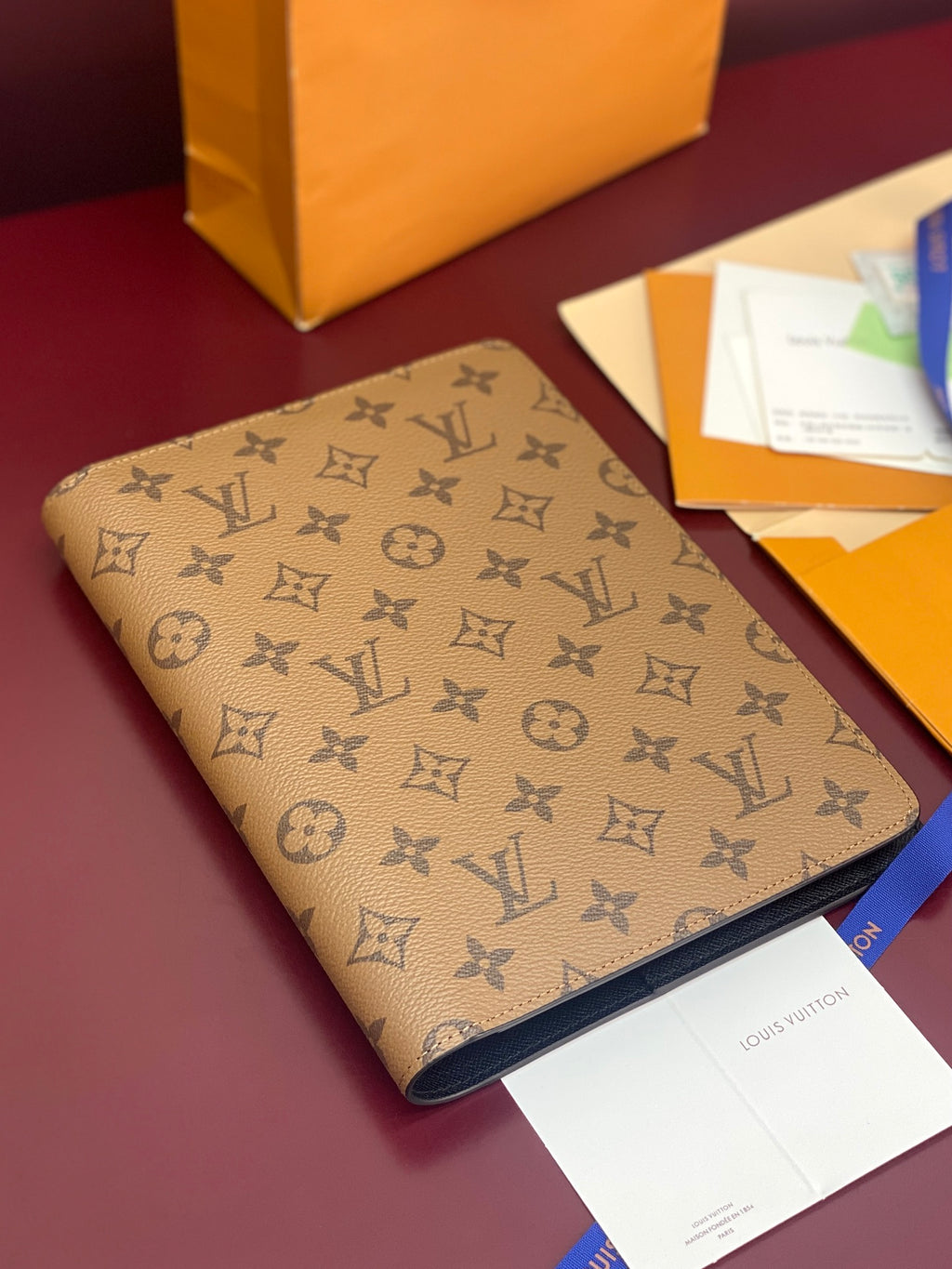 Louis Vuitton small bag in tan monogram canvas with dark leather edging and seam detail.