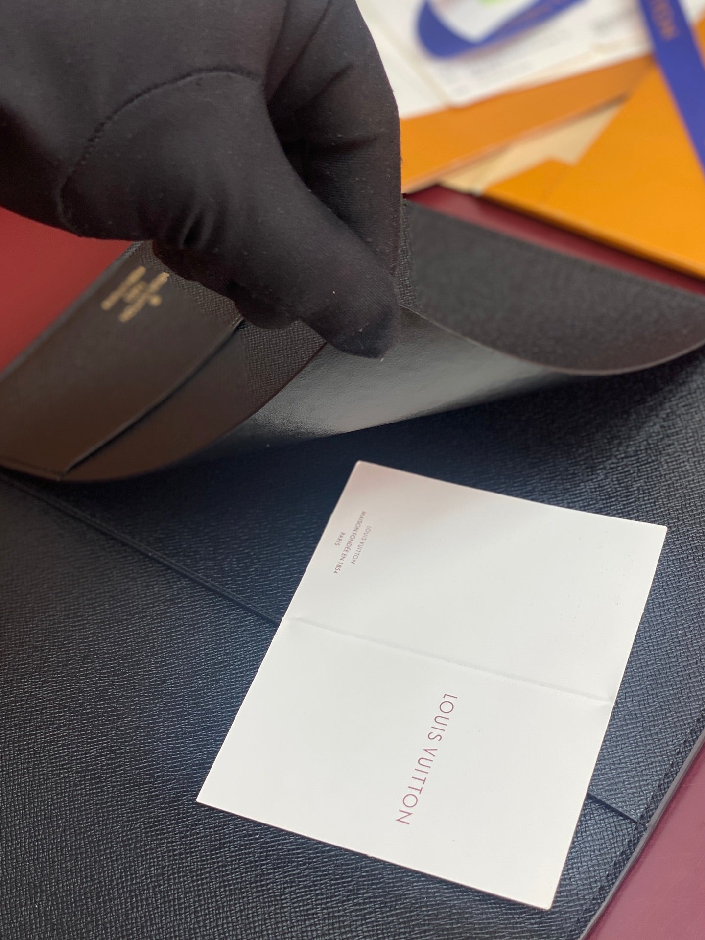 Louis Vuitton textured wallet, dark blue, held with white paper label