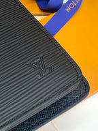 Close-up of dark textured leather wallet edge with Louis Vuitton emblem