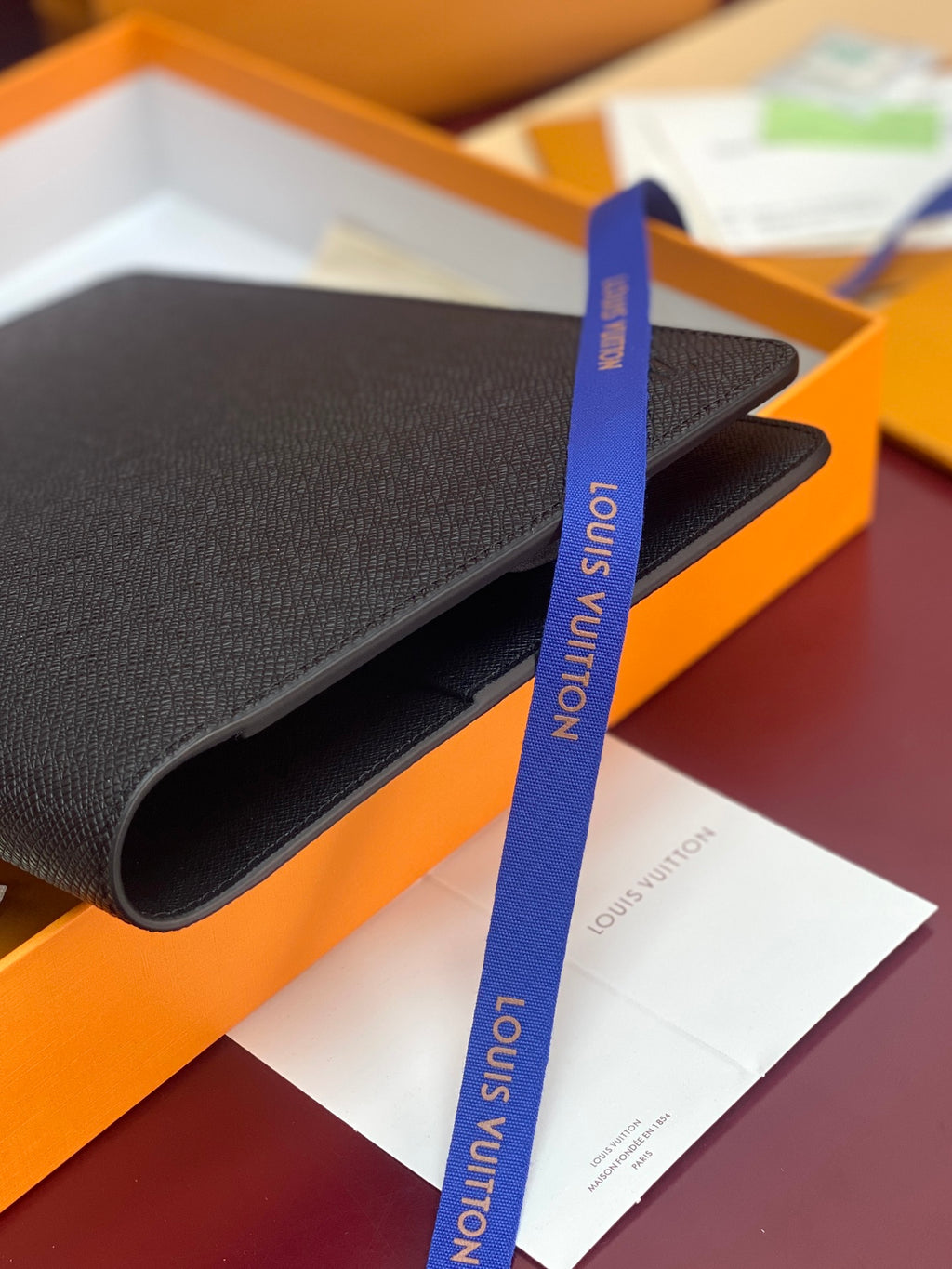 Louis Vuitton small bag close-up with textured leather and blue ribbon