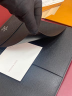 Louis Vuitton small bag with dark textured leather, opened with insert cards