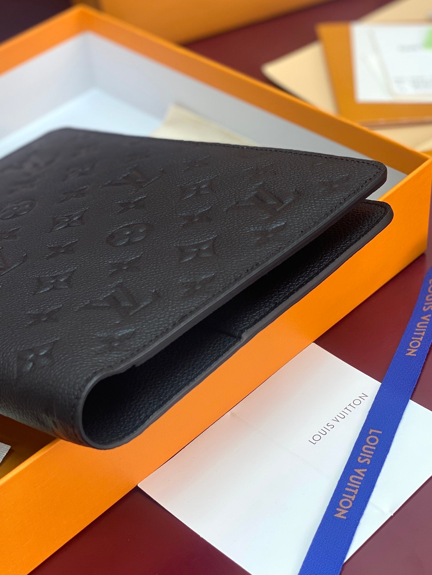Dark embossed monogram leather small bag, close-up of curved edge