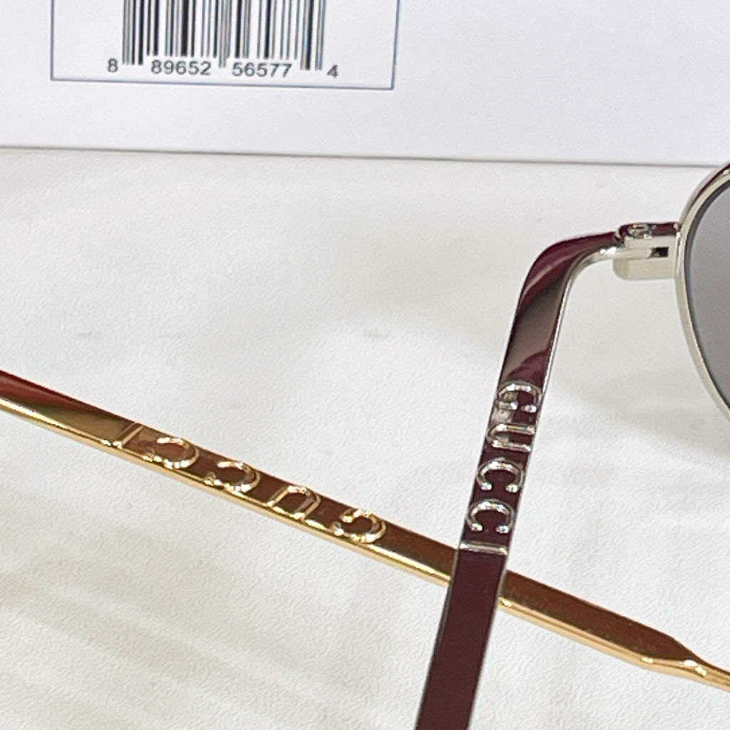 Close-up of gold-tone eyeglass temple with maroon inner section and patterned trim