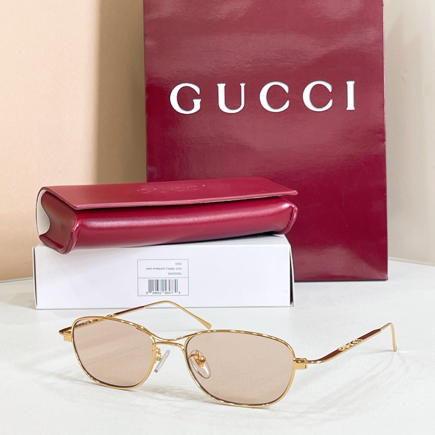 Gold-tone aviator eyeglasses with light pink tinted lenses and metal frame