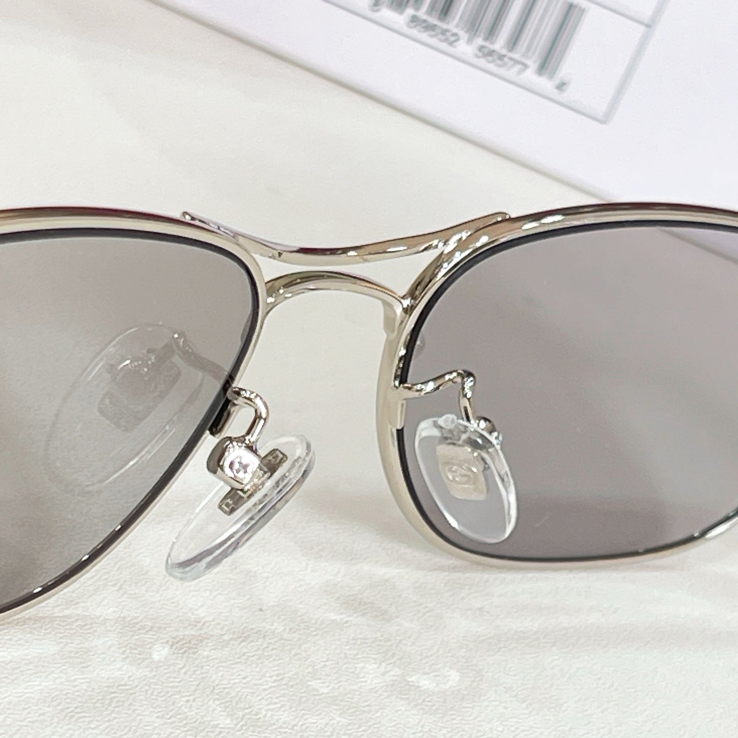 Close-up of gold-tone aviator eyeglass frame and clear hinge detail