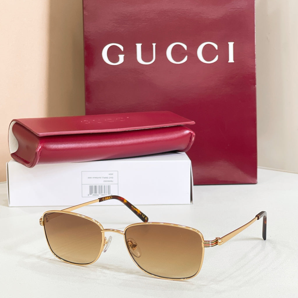 Gold-tone metal sunglasses with amber tinted lenses and curved temple arms