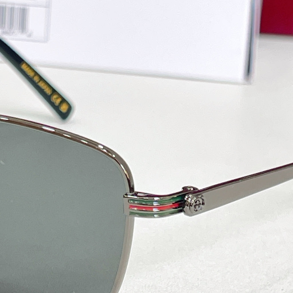Metal sunglasses hinge detail with multicolor stripe and small emblem