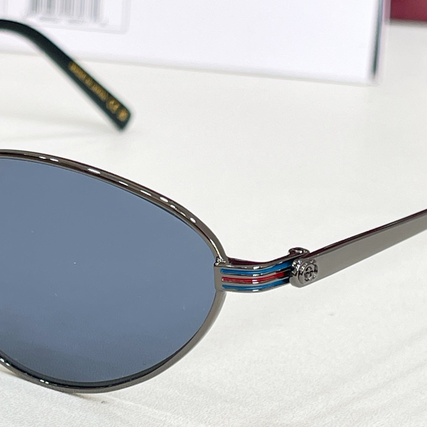 Gucci sunglasses close-up of round lens and striped temple detail