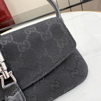 Gray Gucci crossbody bag corner with monogram texture and stitched trim near flap.