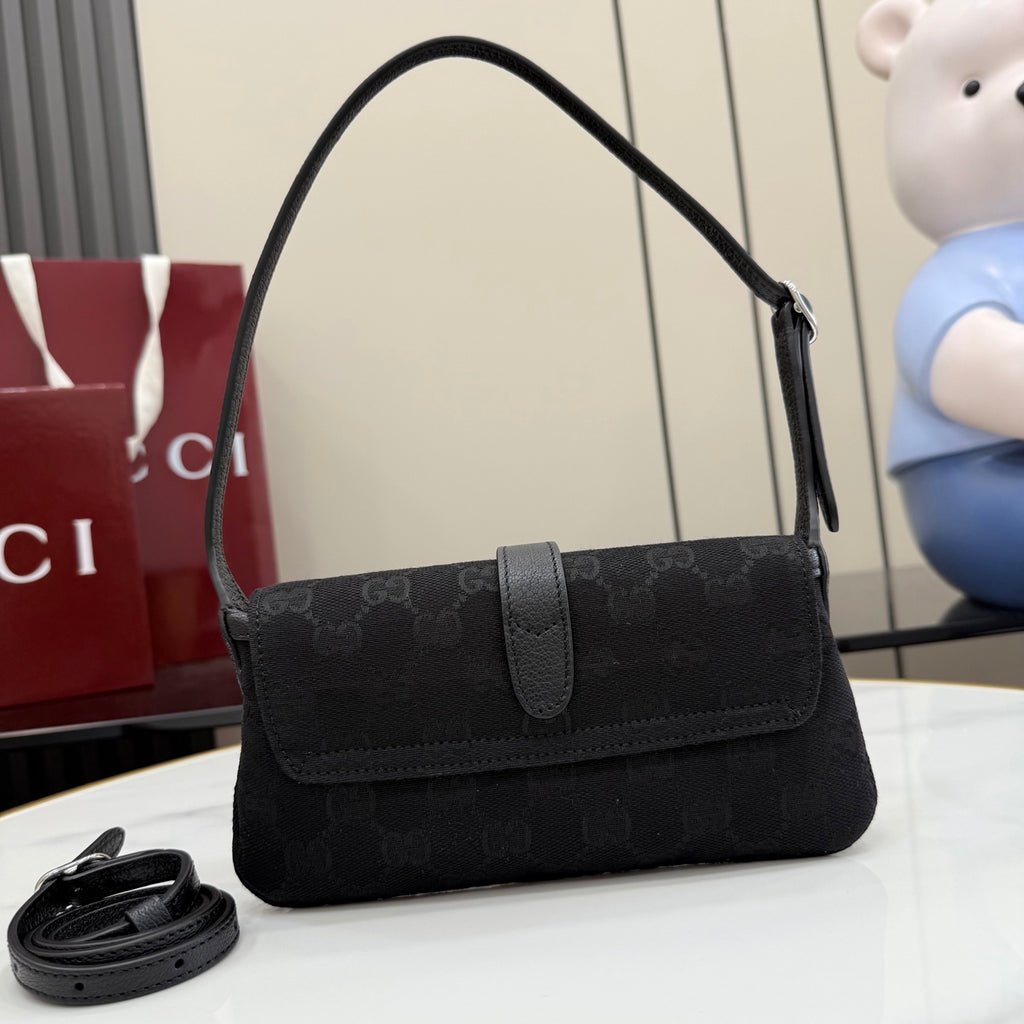 Black Gucci shoulder bag with monogram print and flap front, shown from side angle.