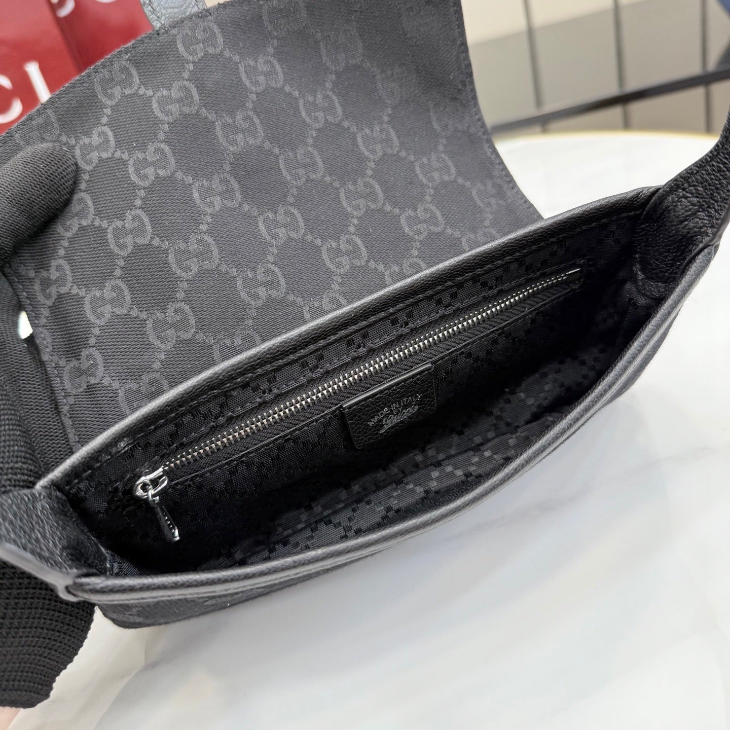 Gray Gucci mini bag interior view with zip closure and dark lined compartment.