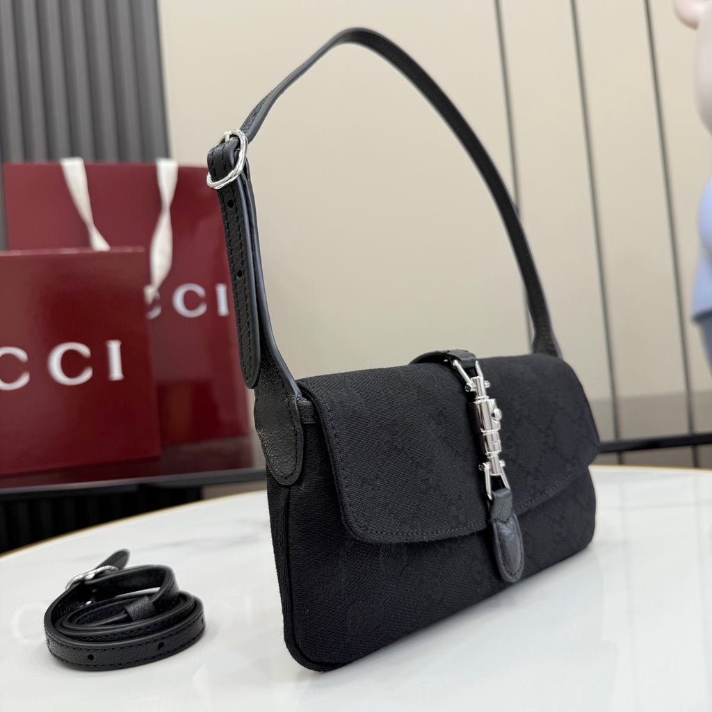 Black Gucci shoulder bag with top handle, flap front, and silver chain clasp hardware.