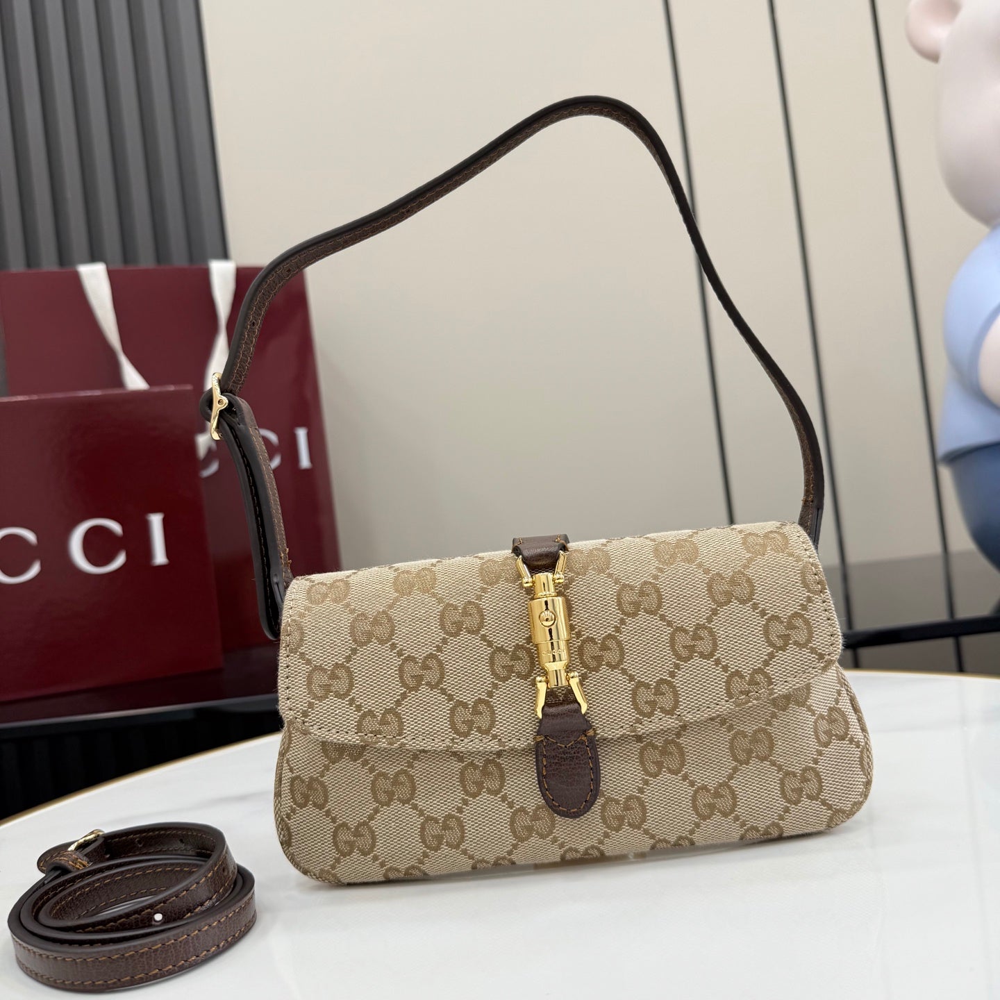 Beige and dark brown GG-pattern shoulder bag with gold clasp and adjustable strap