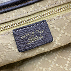 Beige bag leather label with dark border, showing Made in Italy and signature-style logo