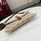 Beige GG-pattern shoulder bag folded side profile with dark brown trim and gold hardware