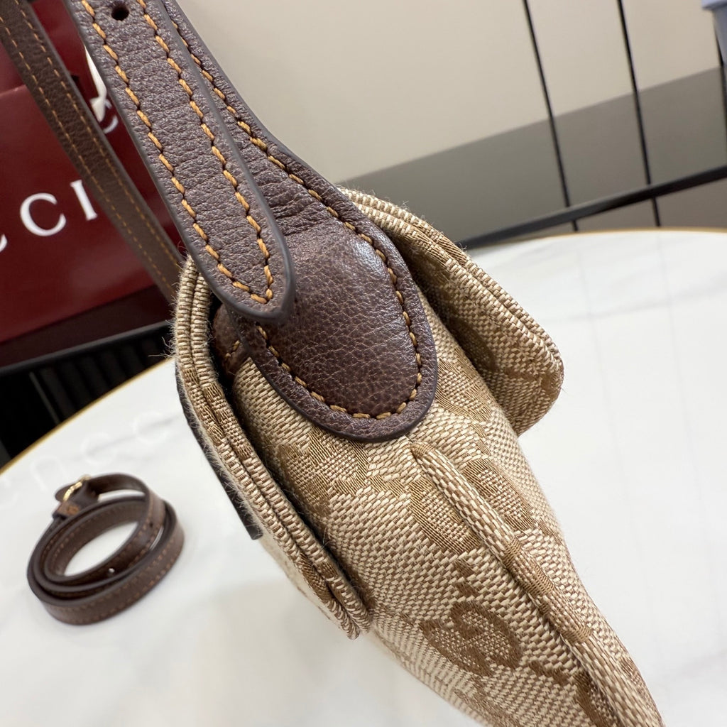 Monogram canvas bag handle with brown leather patch and rolled leather edge