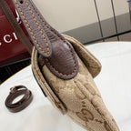 Monogram canvas bag handle with brown leather patch and rolled leather edge