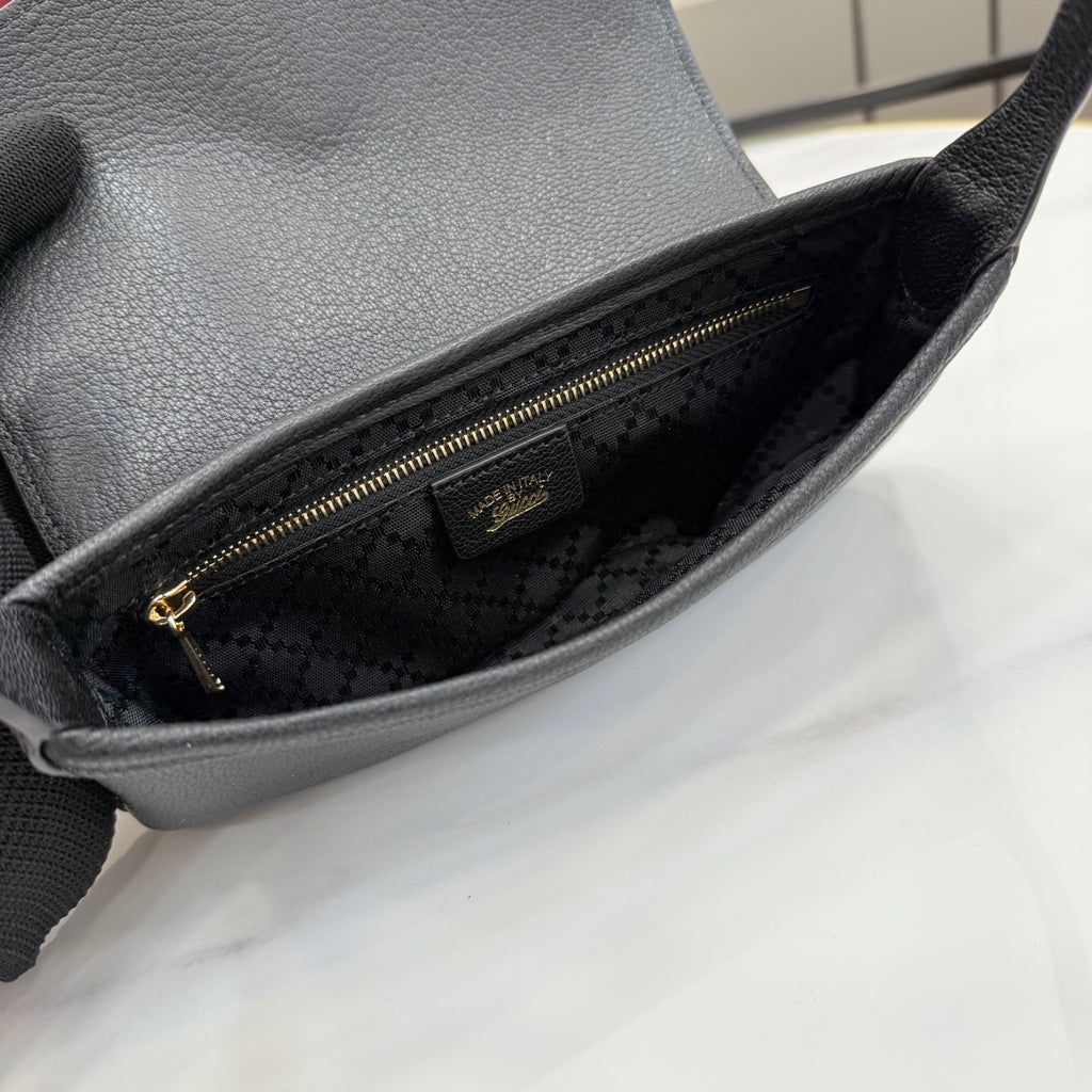 Black Gucci shoulder bag interior with fabric lining and zipper pocket, close-up