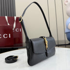 Black Gucci shoulder bag with top handle, flap front, and gold clasp, side view