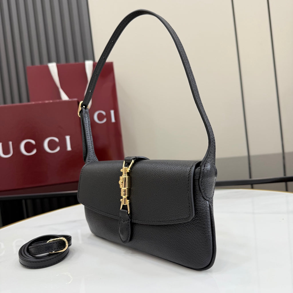 Black Gucci shoulder bag with top handle and flap front, gold clasp detail